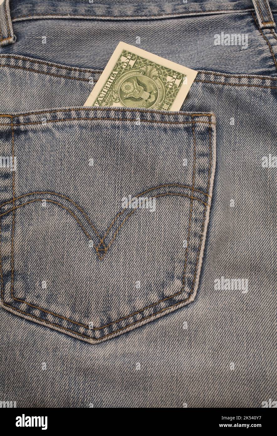 US dollar sticking out of back pocket on pair of blue jeans. Stock Photo