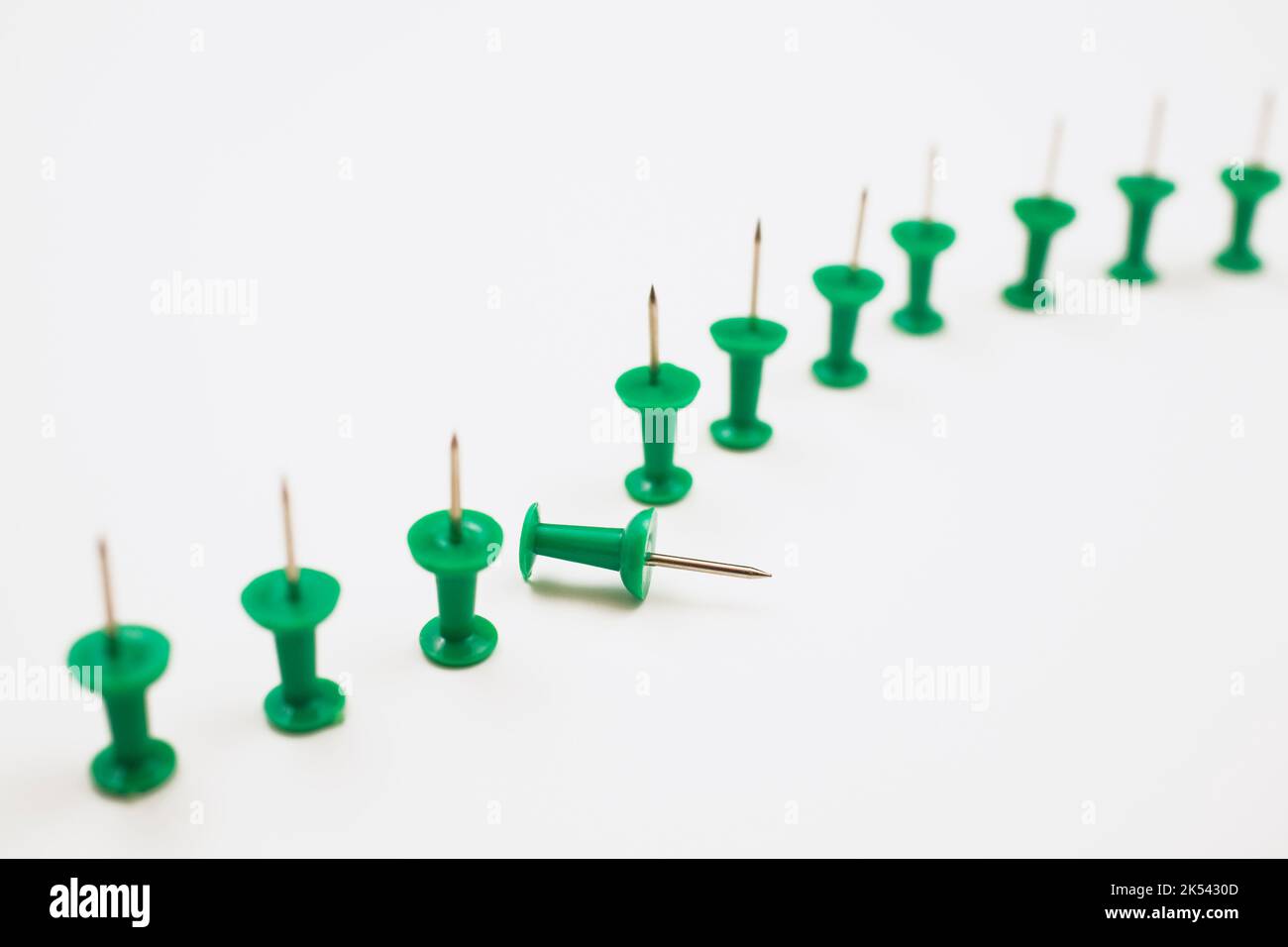 Green pushpins on white background. Stock Photo