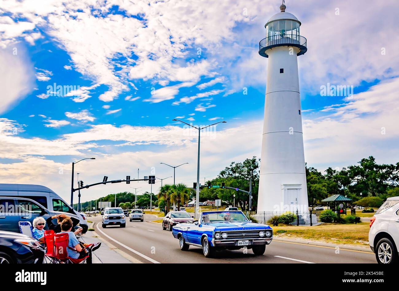 A vintage Oldsmobile convertible passes the Biloxi lighthouse during the 26th annual Cruisin’ the Coast antique car festival in Biloxi, Mississippi. Stock Photo