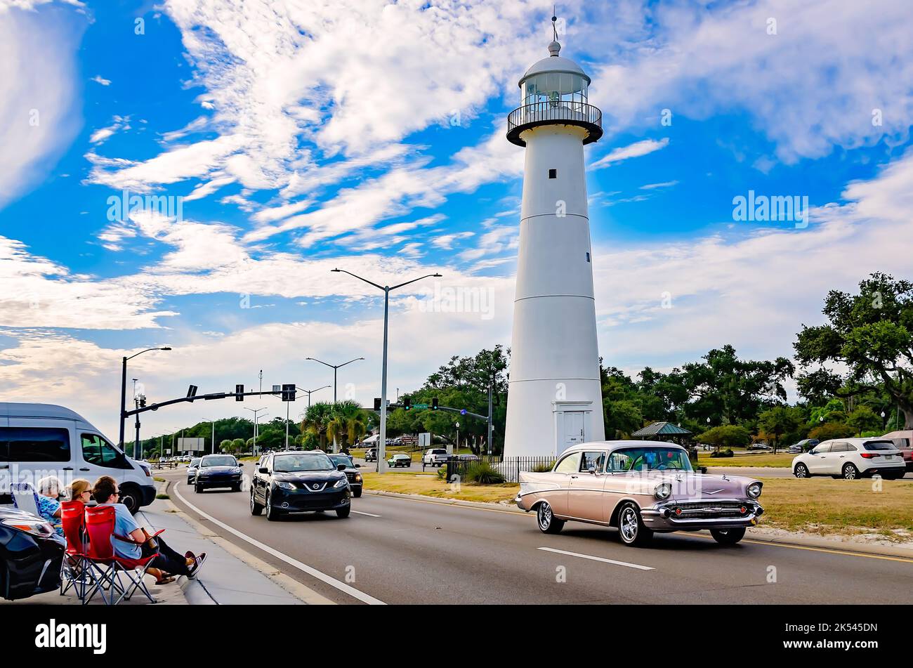 A 1957 Chevrolet Bel Air passes the Biloxi lighthouse during the 26th annual Cruisin’ the Coast antique car festival in Biloxi, Mississippi. Stock Photo