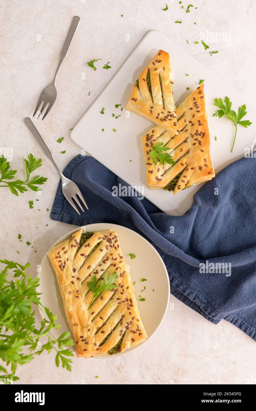 Spinach puff pastry with ricotta cheese and parsley leaves on white