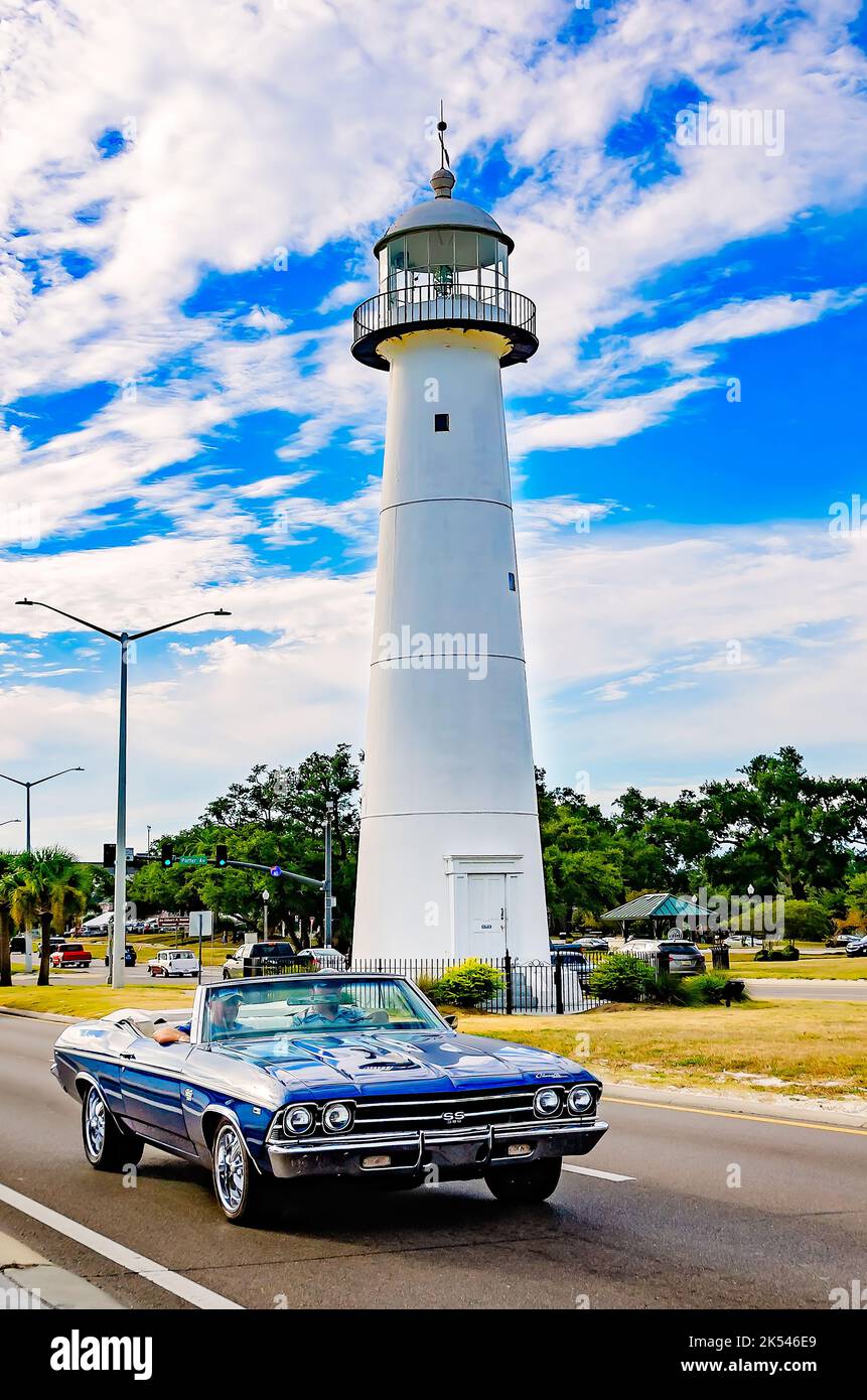 A vintage convertible passes the Biloxi lighthouse during the 26th