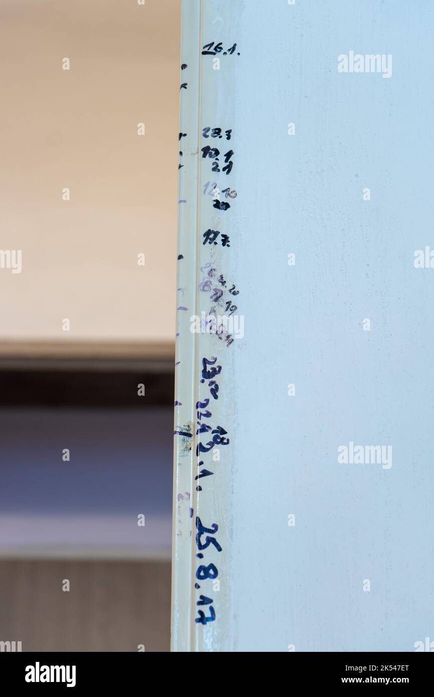 The timeline of children's growth over the course of several years written on the door frame. Stock Photo