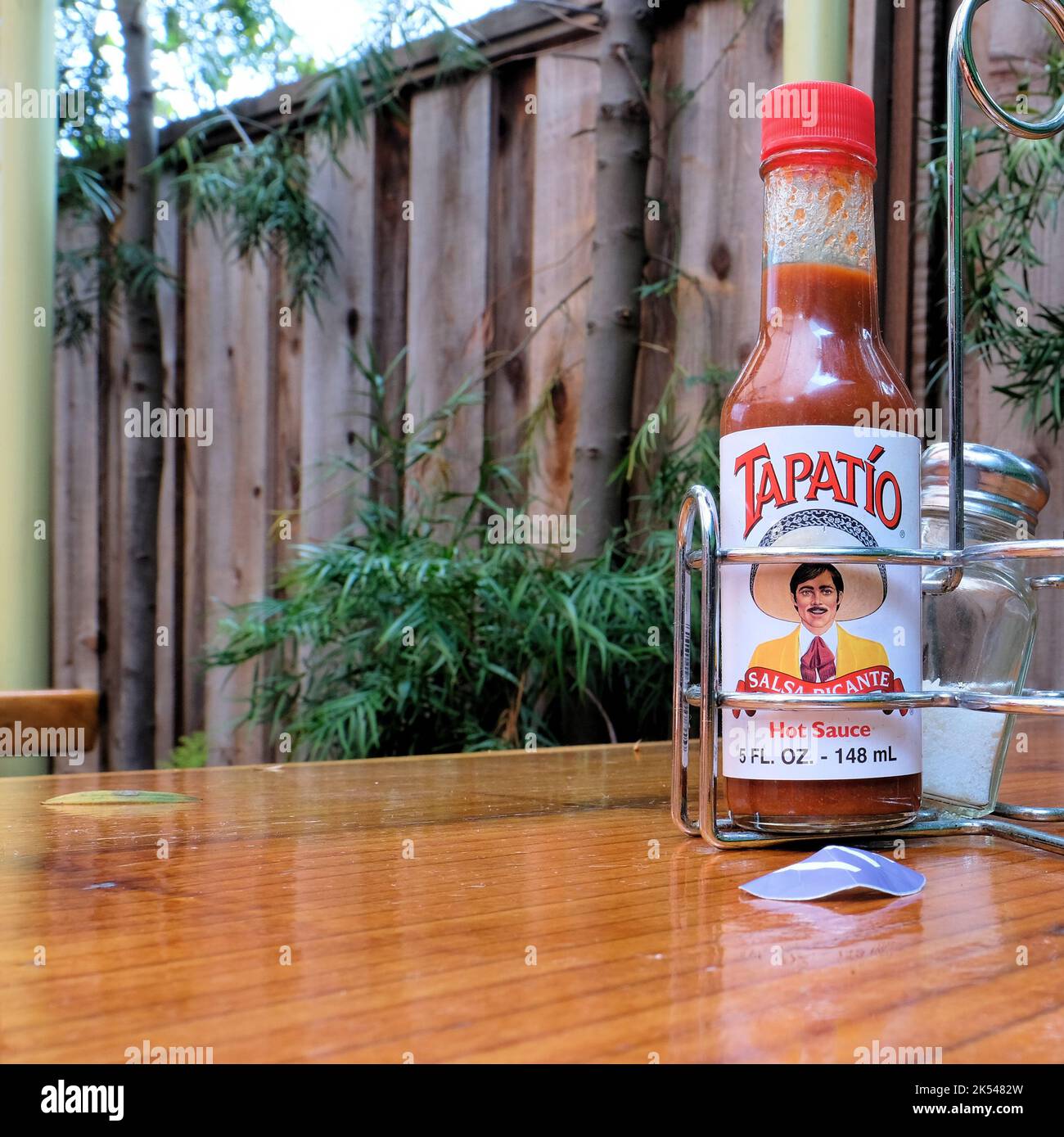 Tapatio hot sauce bottle and salt shaker in a metal condiment caddy on