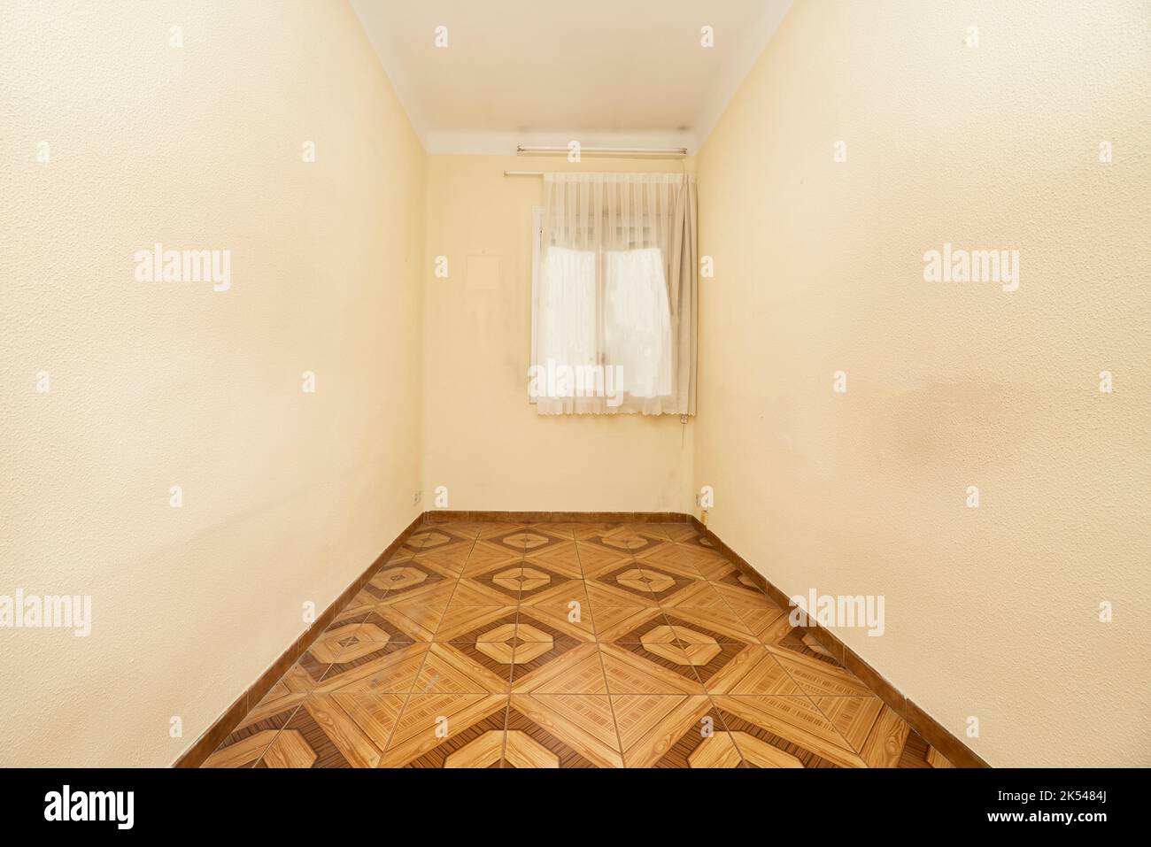 Empty room in old apartment built with modest qualities, brown tiles ...