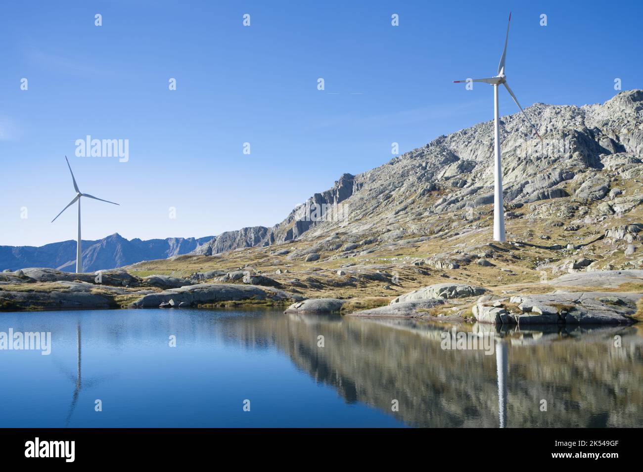 Lake in the Swiss mountains with wind turbines Stock Photo