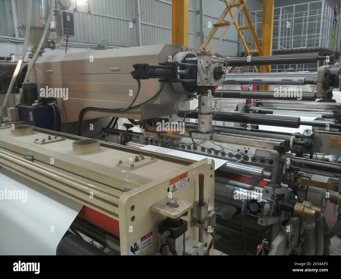 Kolkata, West Bengal, India - 12th January 2019 : Extruder and roller running for coating polyethylene , PE on paper, for making paper cups. Stock Photo