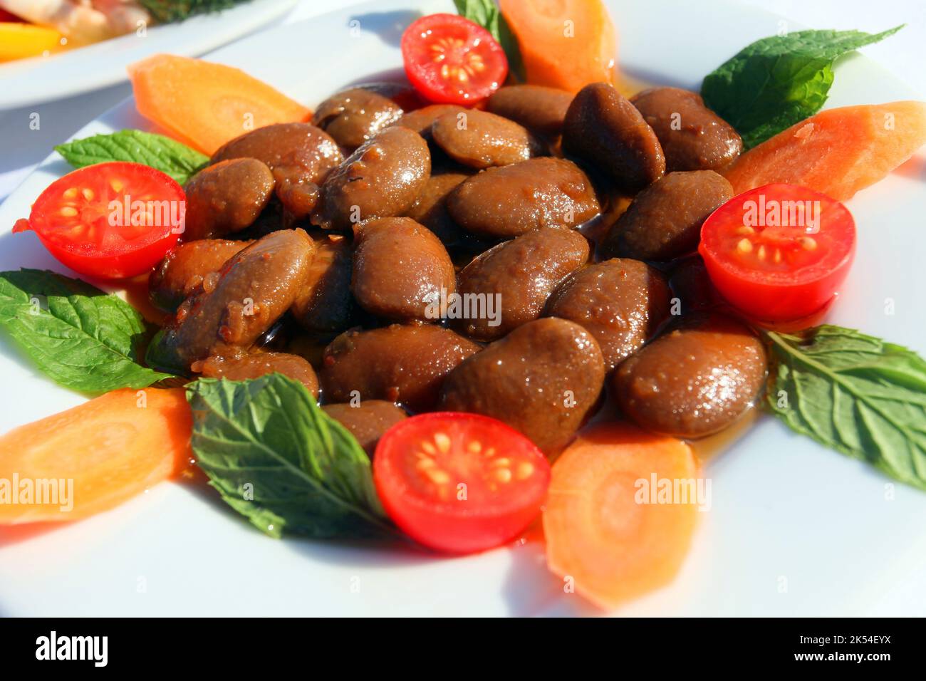 Turkish appetizer food 'Roman Bean' (Turkish: Barbunya Pilaki) on the dinner plate. Stock Photo
