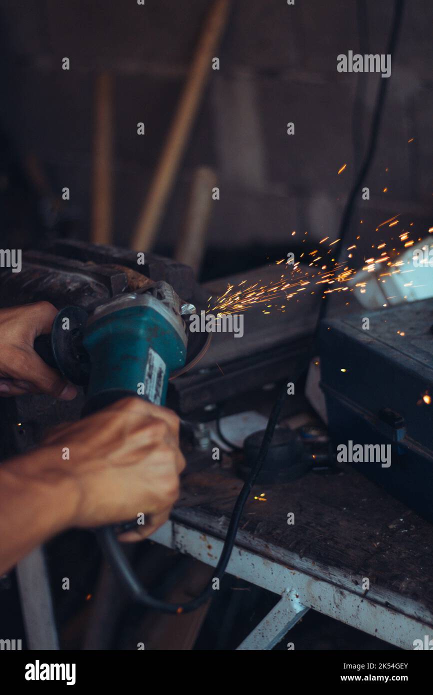 A person using a grinder in workshop Stock Photo