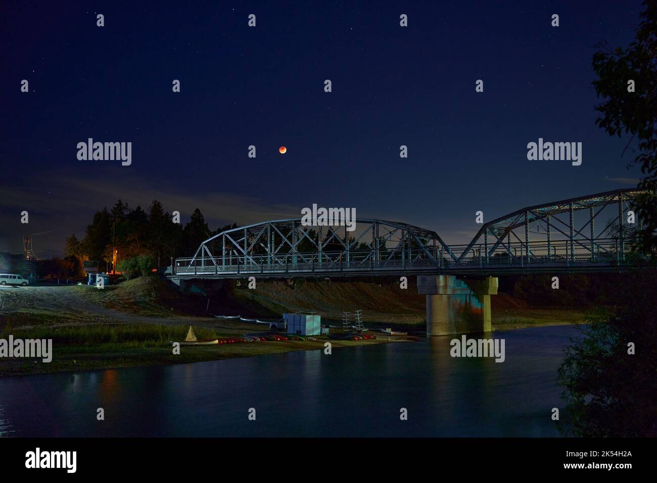 Lunar eclipse seen at the Veterans Memorial Bridge on the Russian River in Healdsburg, California. Stock Photo