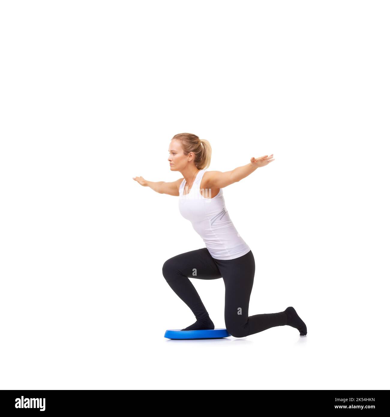 Keeping it steady. Full length shot of a woman doing balance exercises isolated on white Stock