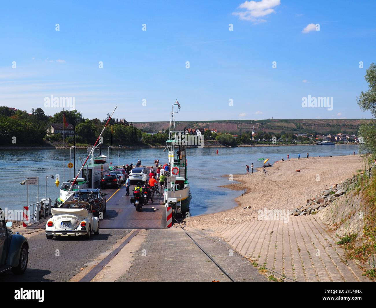 The cars, bikes and people going up on a ferry at the Rhine river of Nierstein town Stock Photo