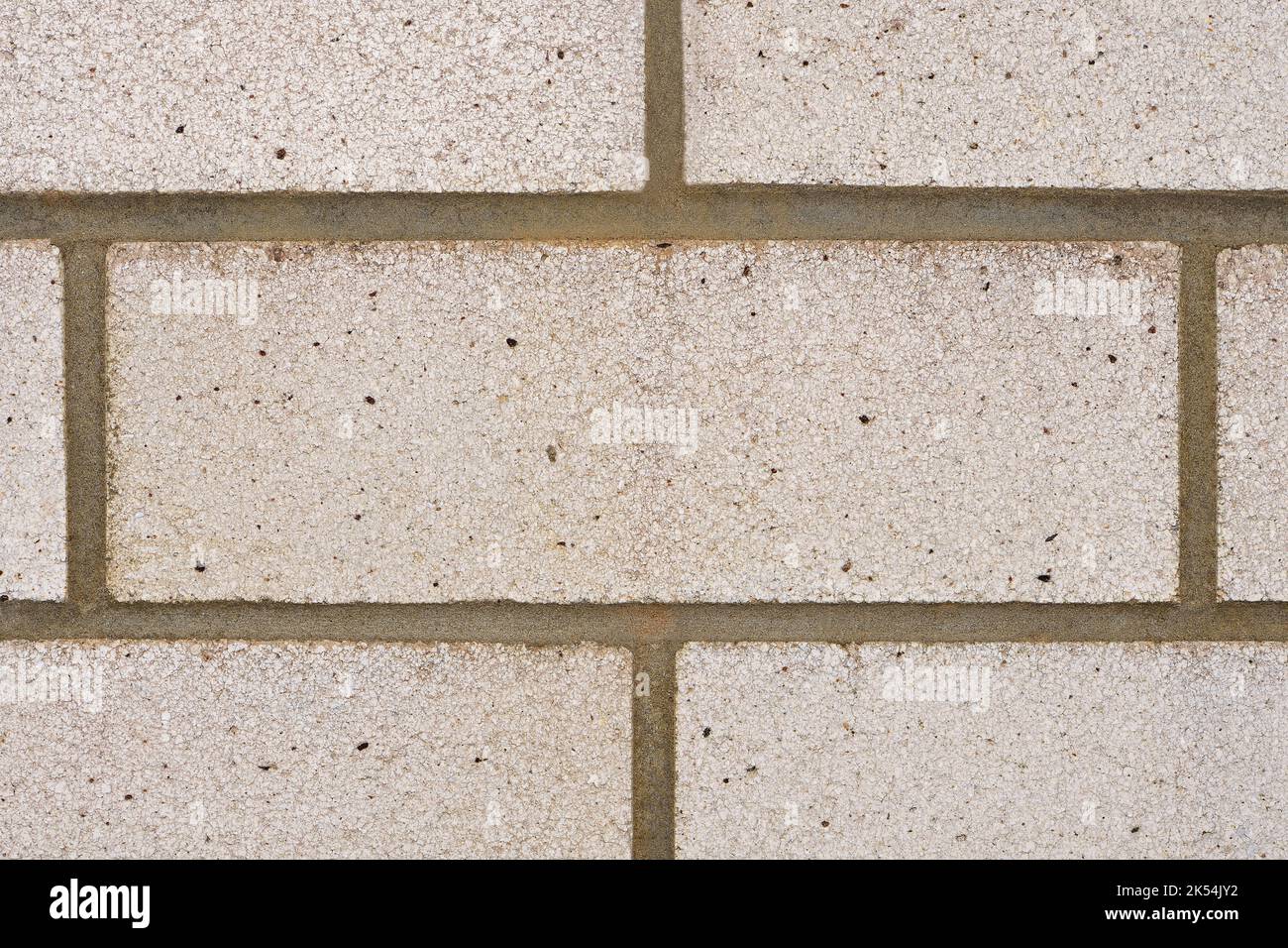 A closeup of a section of white house bricks with vertical and horizontal joint lines creating