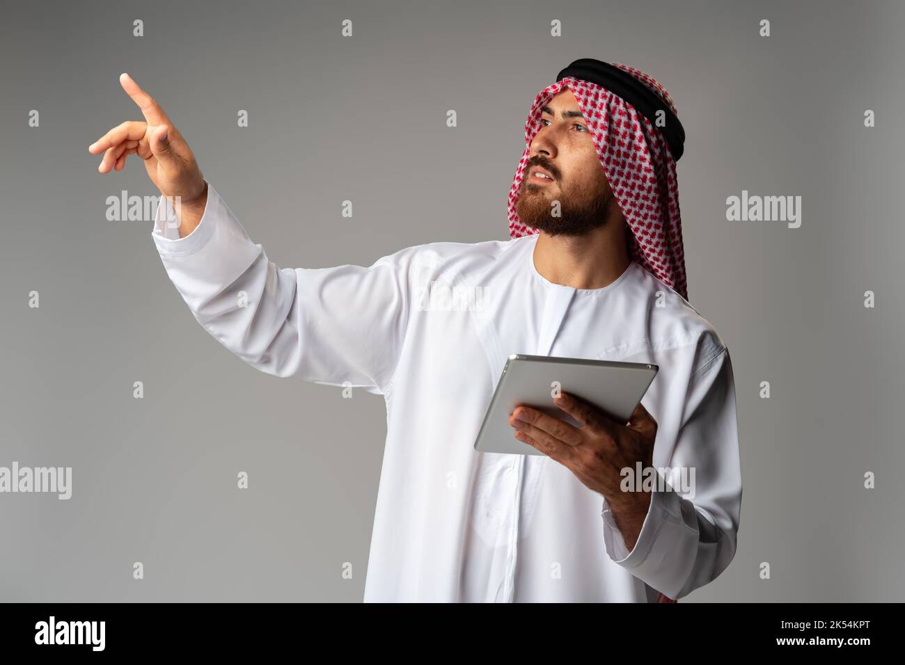 Arab businessman using digital tablet on gray background Stock Photo