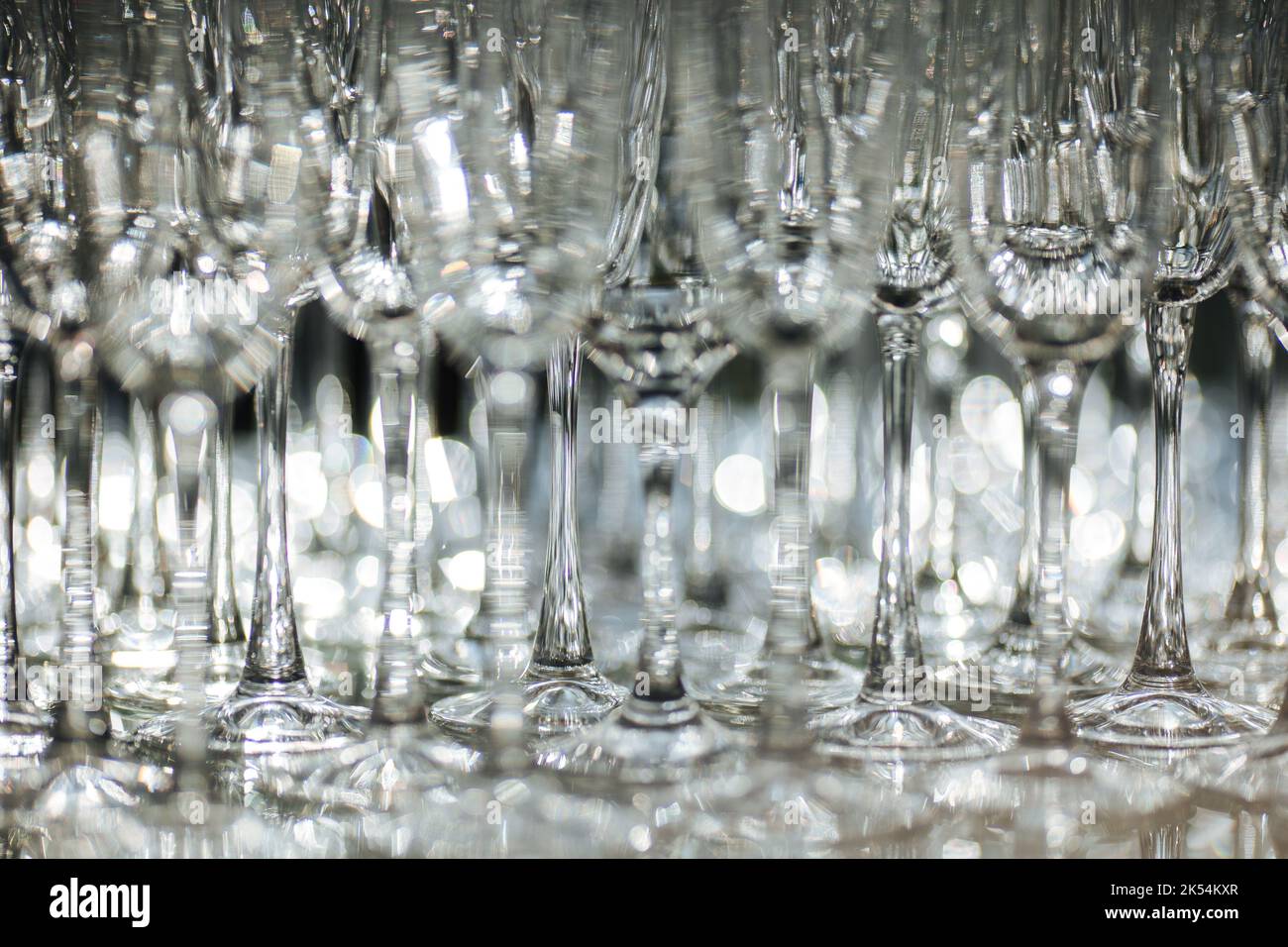 Group of empty and transparent champagne glasses in a restaurant. Clean glasses on a table prepared by the bartender for champagne. Catering for the event preparation, empty glasses for drink. Stock Photo