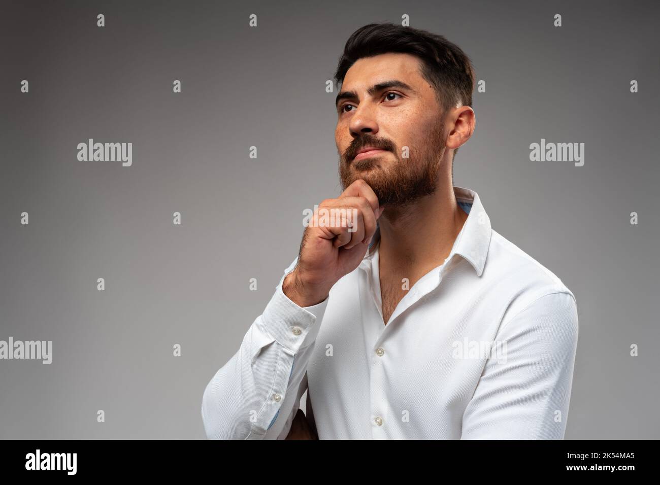 Studuo shot of thinking businessman standing over gray background Stock Photo
