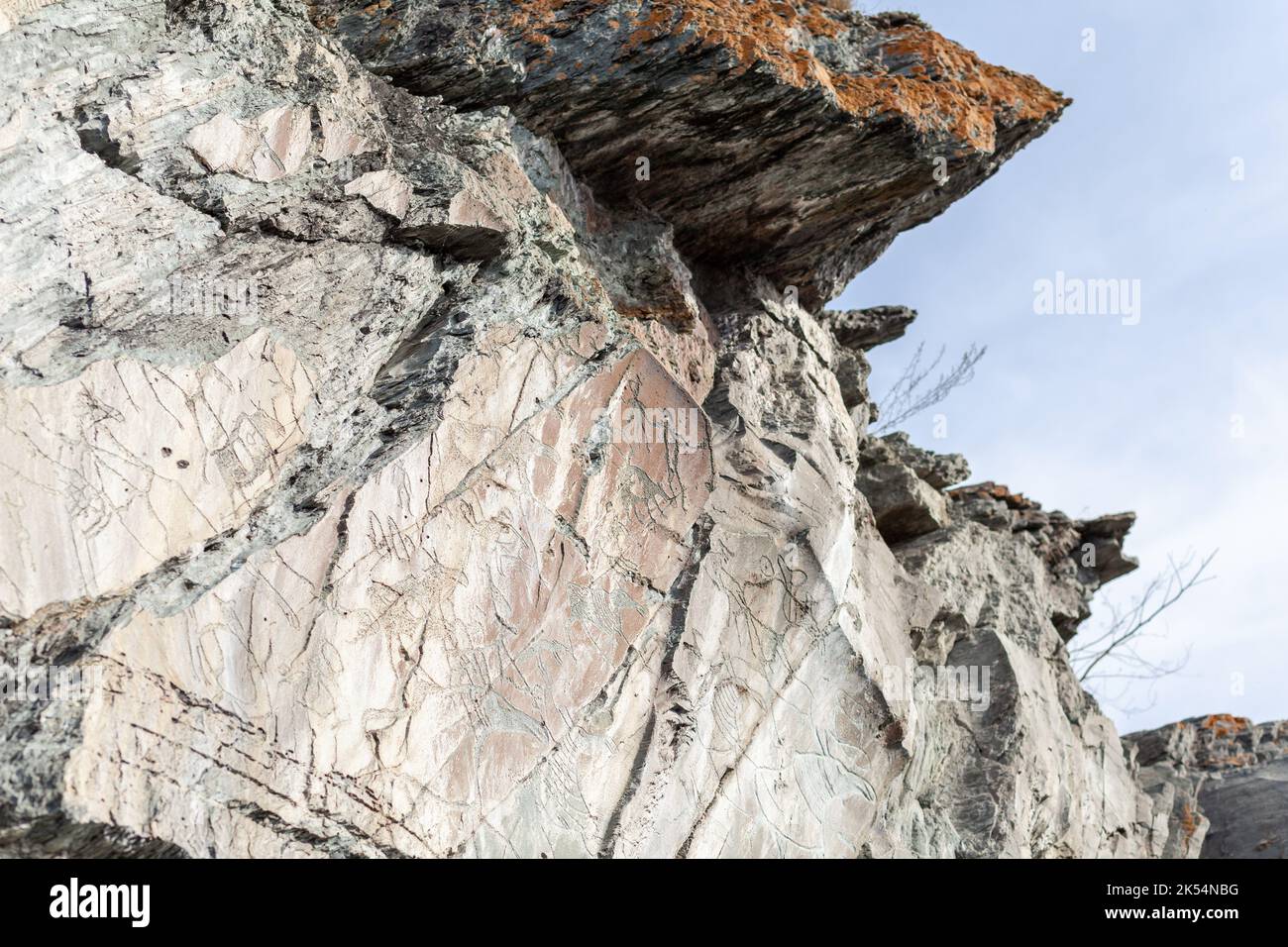 Old rock carvings of an ancient man on rocks in Siberia. The drawings ...