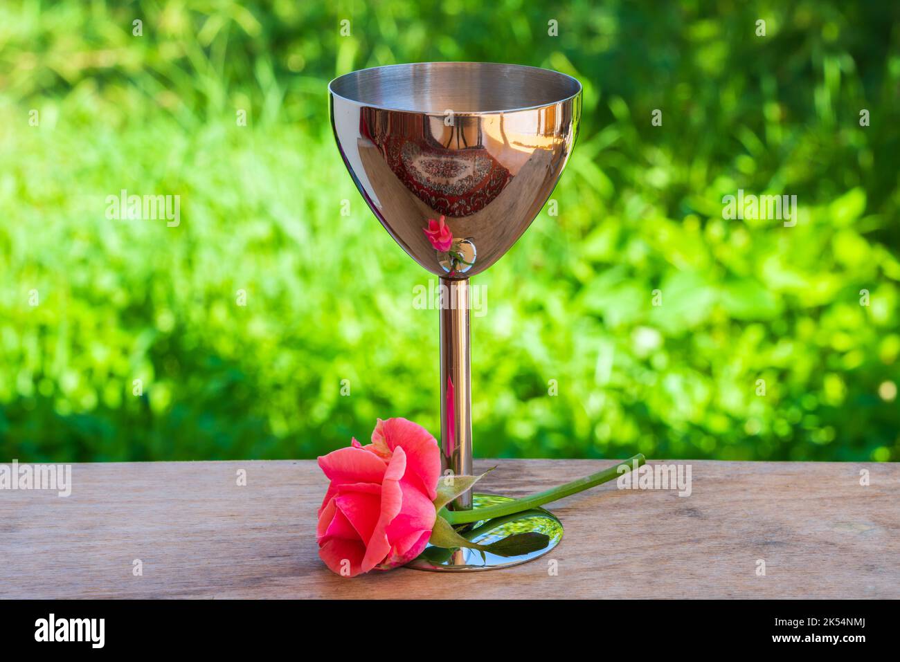 Silver shot glass on a wooden table in the garden Stock Photo