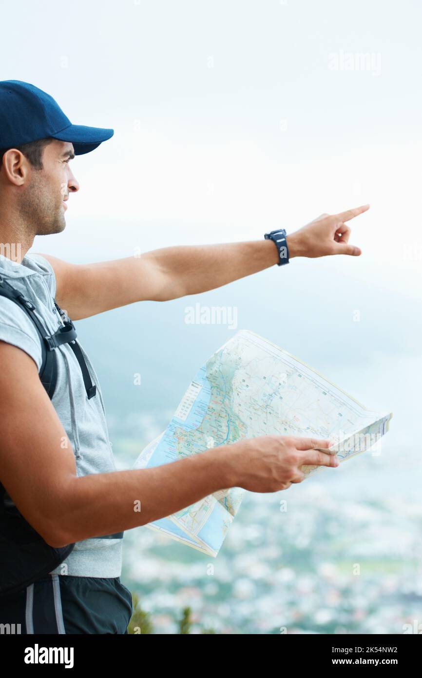 Determining his place in the world. Young hiker determining his ...
