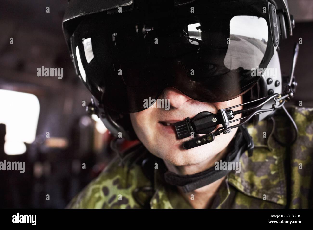 Smiling in the sky. A helicopter pilot wearing a helmet and smiling at the camera. Stock Photo