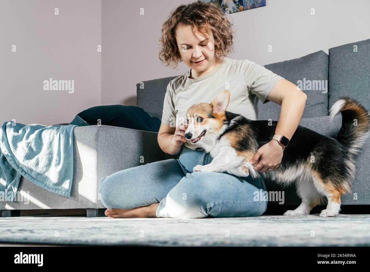 Curly haired glad, cheerful barefoot woman with dog Obedience