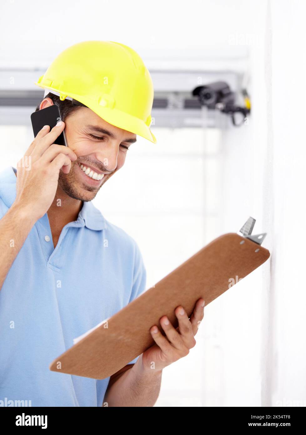 All safe and secure. a handsome young man installing a security camera. Stock Photo