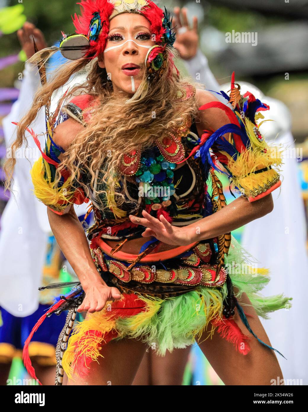 Participants and dancers in vibrant costumes at Notting Hill Carnival