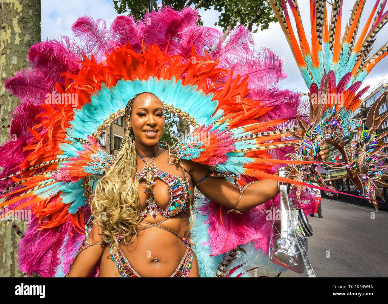 Samba dancer smiles in sparkly, feathered costume with, Notting Hill