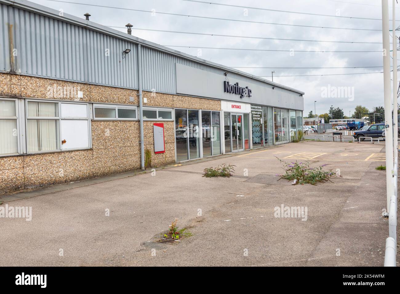 An empty, closed car showroom with weeds in the forecourt Stock Photo