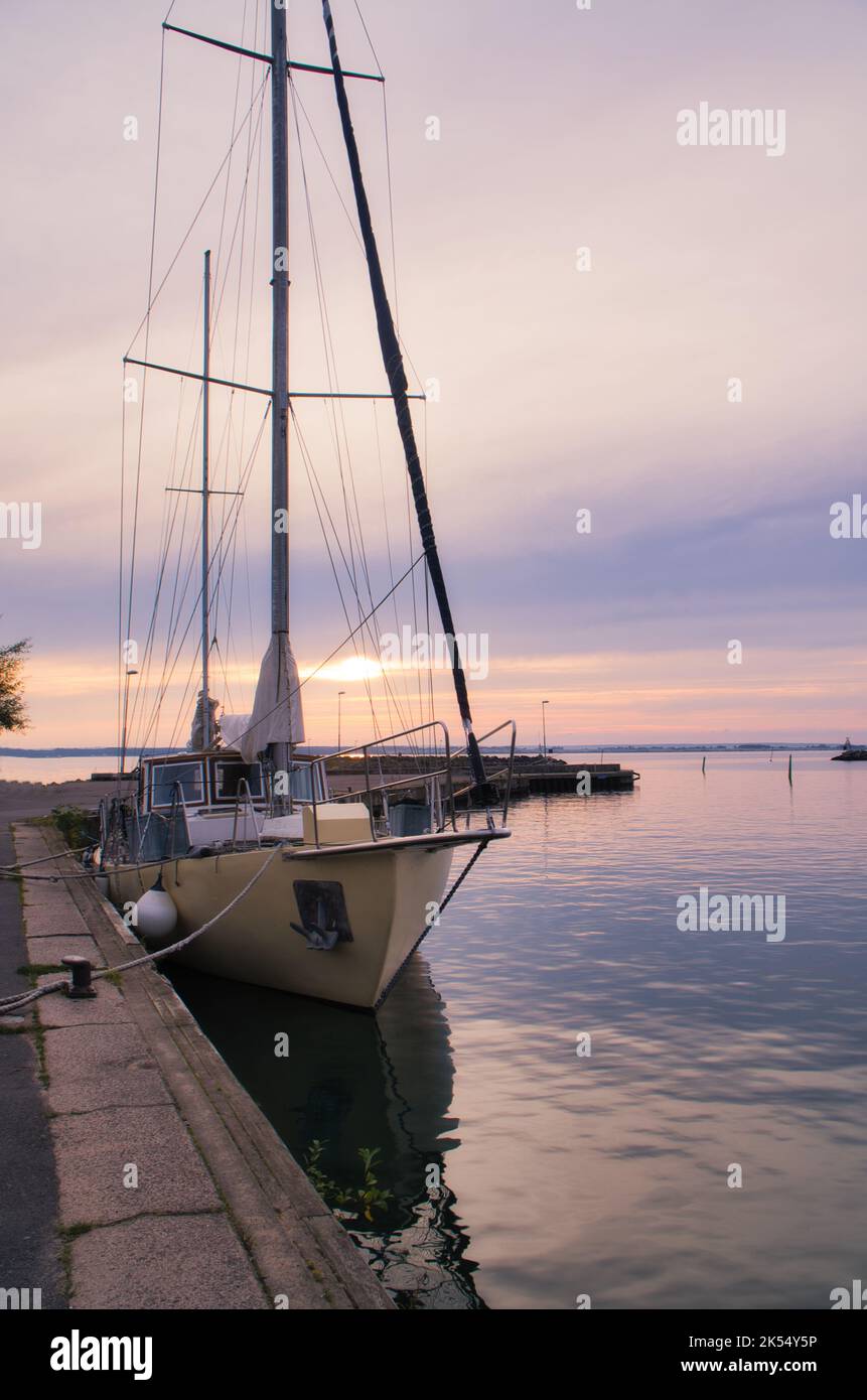 Sailing ship in the harbor of lake Vaettern at sunset. Lighthouse in ...