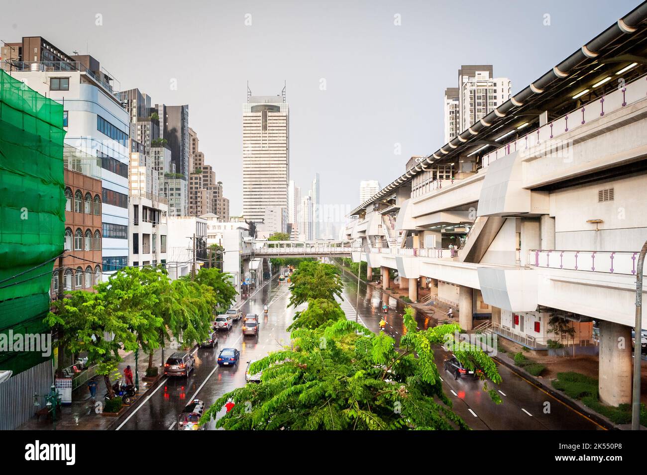 Views down a main road in central Bangkok, Thailand  on a rainy day showing the sky train to the right. Stock Photo