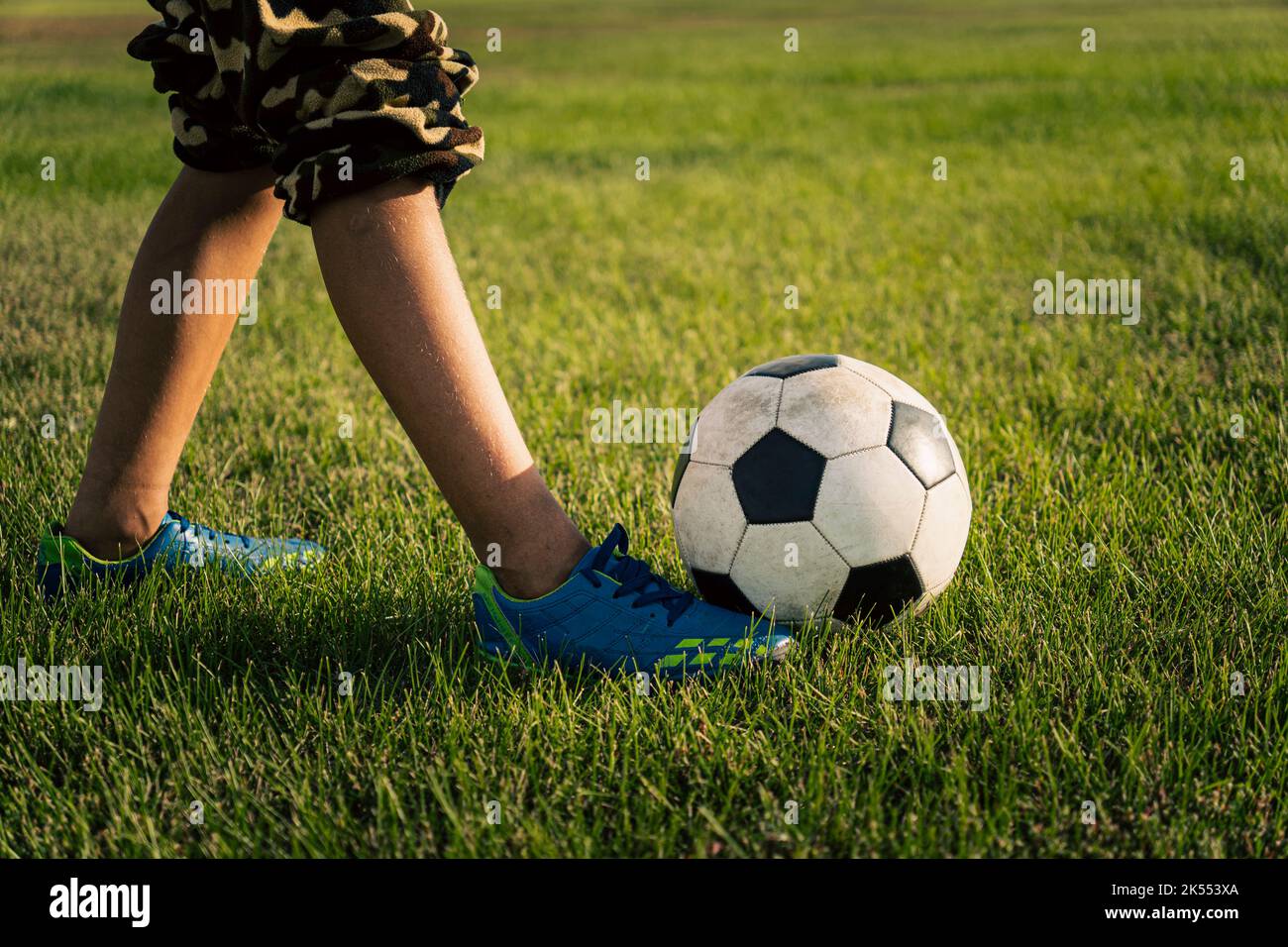 classical black and white football ball and legs of a footballer on the