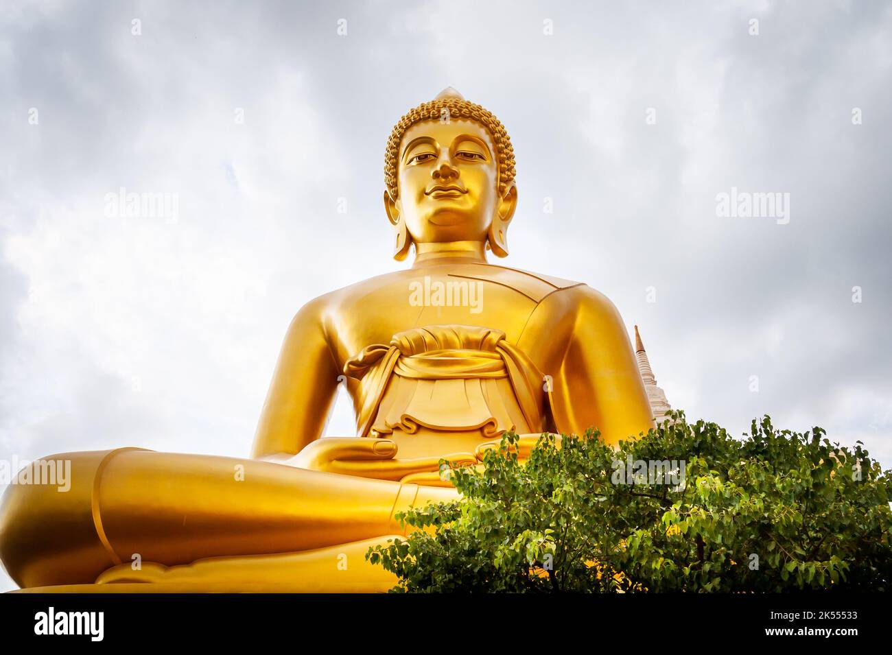The giant golden Buddha looms large above the city of Bangkok Thailand at Wat Paknam. Temple full name; Wat Pak Nam Phasi Cheroen. Stock Photo
