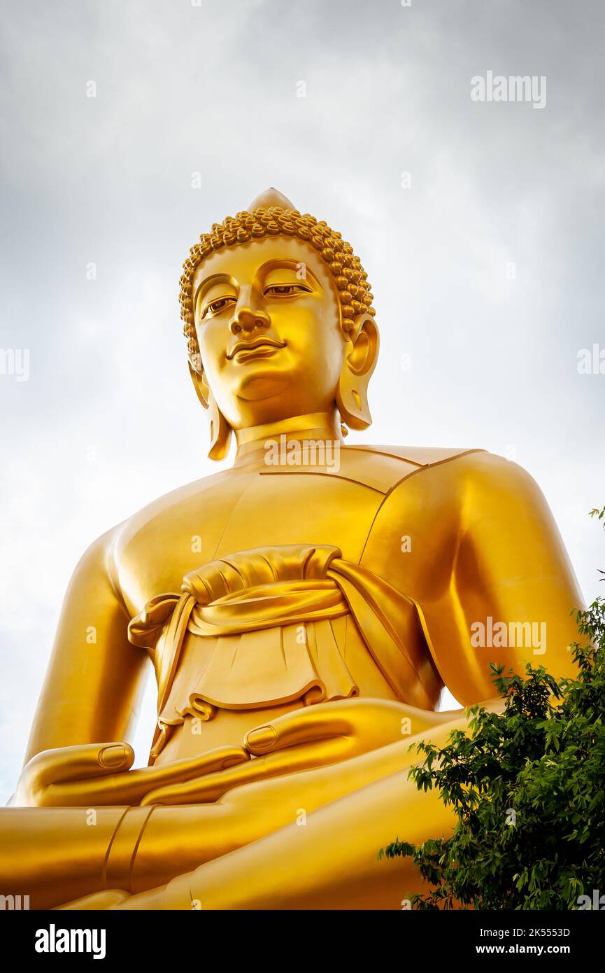 The giant golden Buddha looms large above the city of Bangkok Thailand at Wat Paknam. Temple full name; Wat Pak Nam Phasi Cheroen. Stock Photo