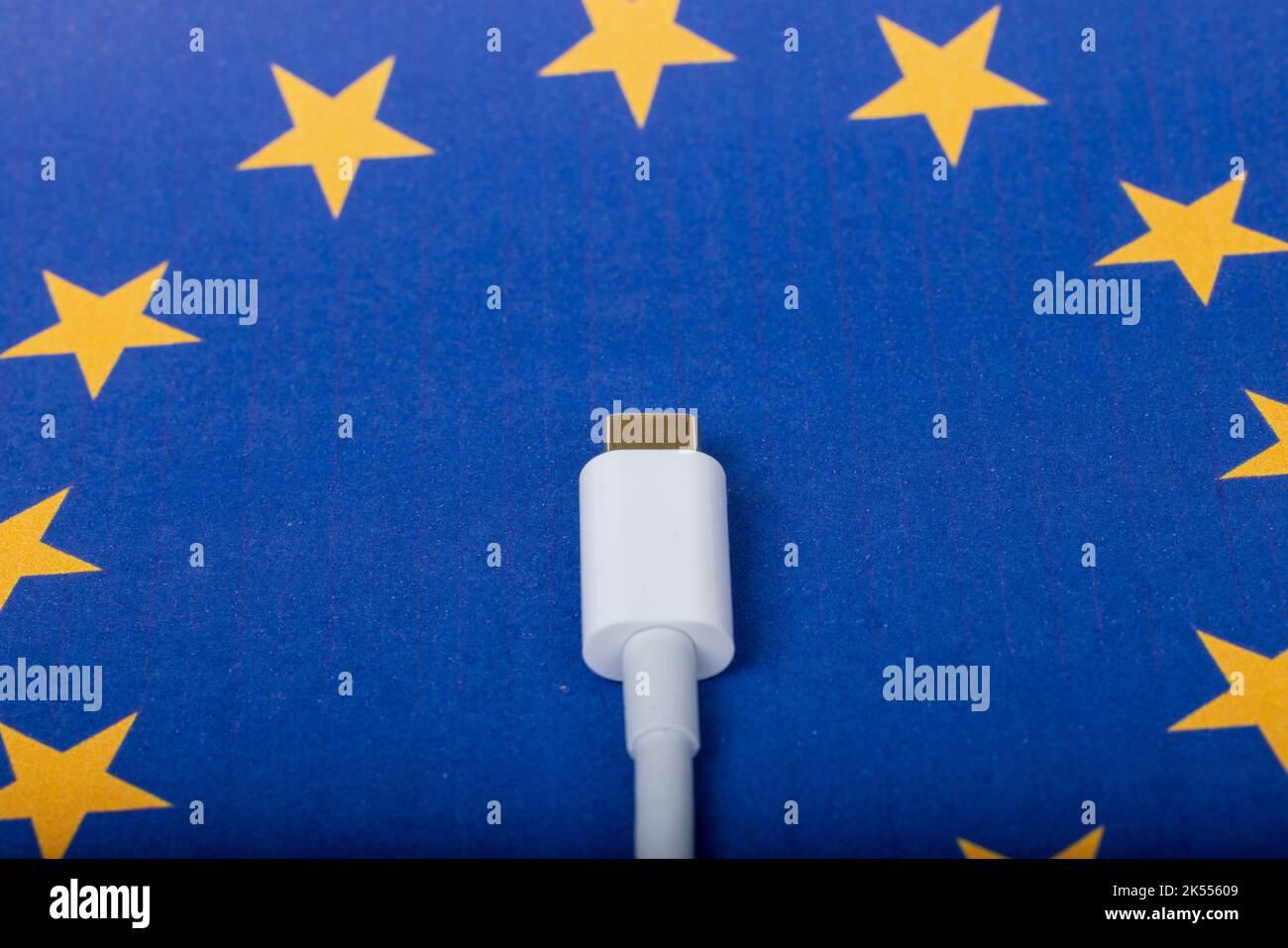 Concept for EU law to force USB-C chargers for all phones. EUROPEAN UNION flag and USBC universal charging cable as a standard for small electronic de Stock Photo