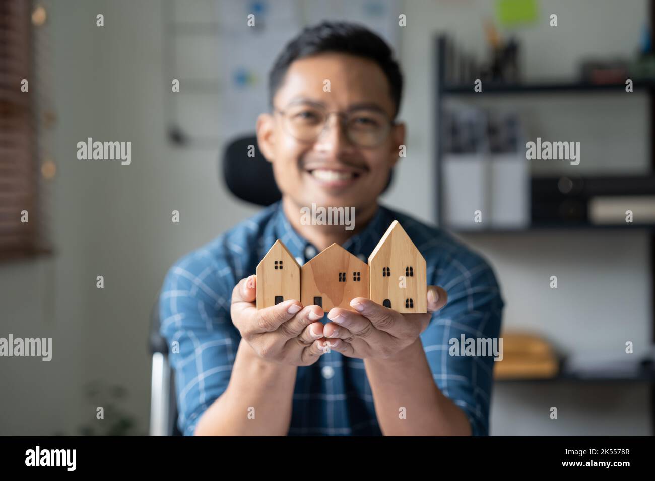 Real estate agent, wooden house model in male hand Stock Photo - Alamy