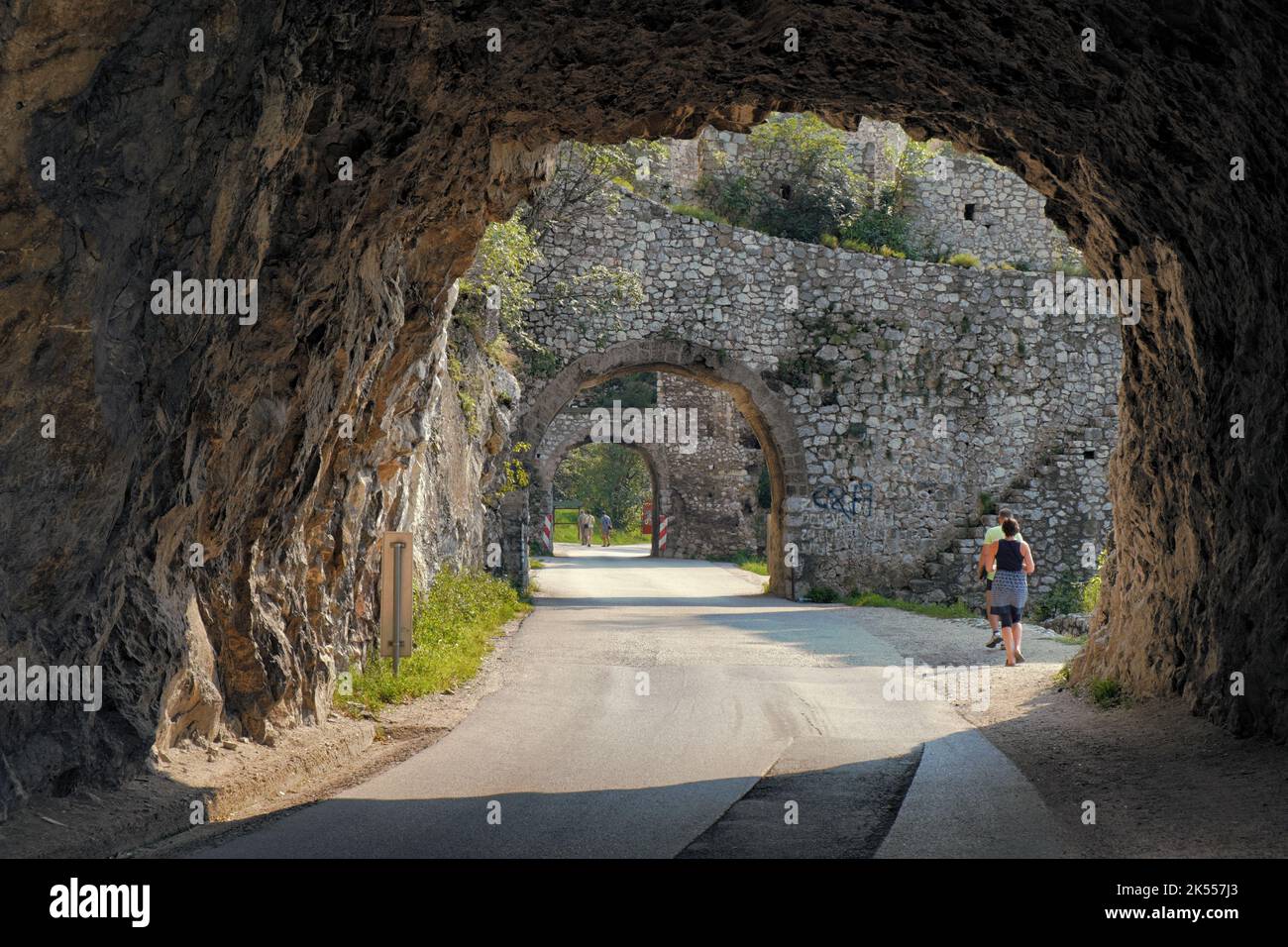 tourists walking a road with tunnel and stone arches of Golubac Fortress, Serbia Stock Photo