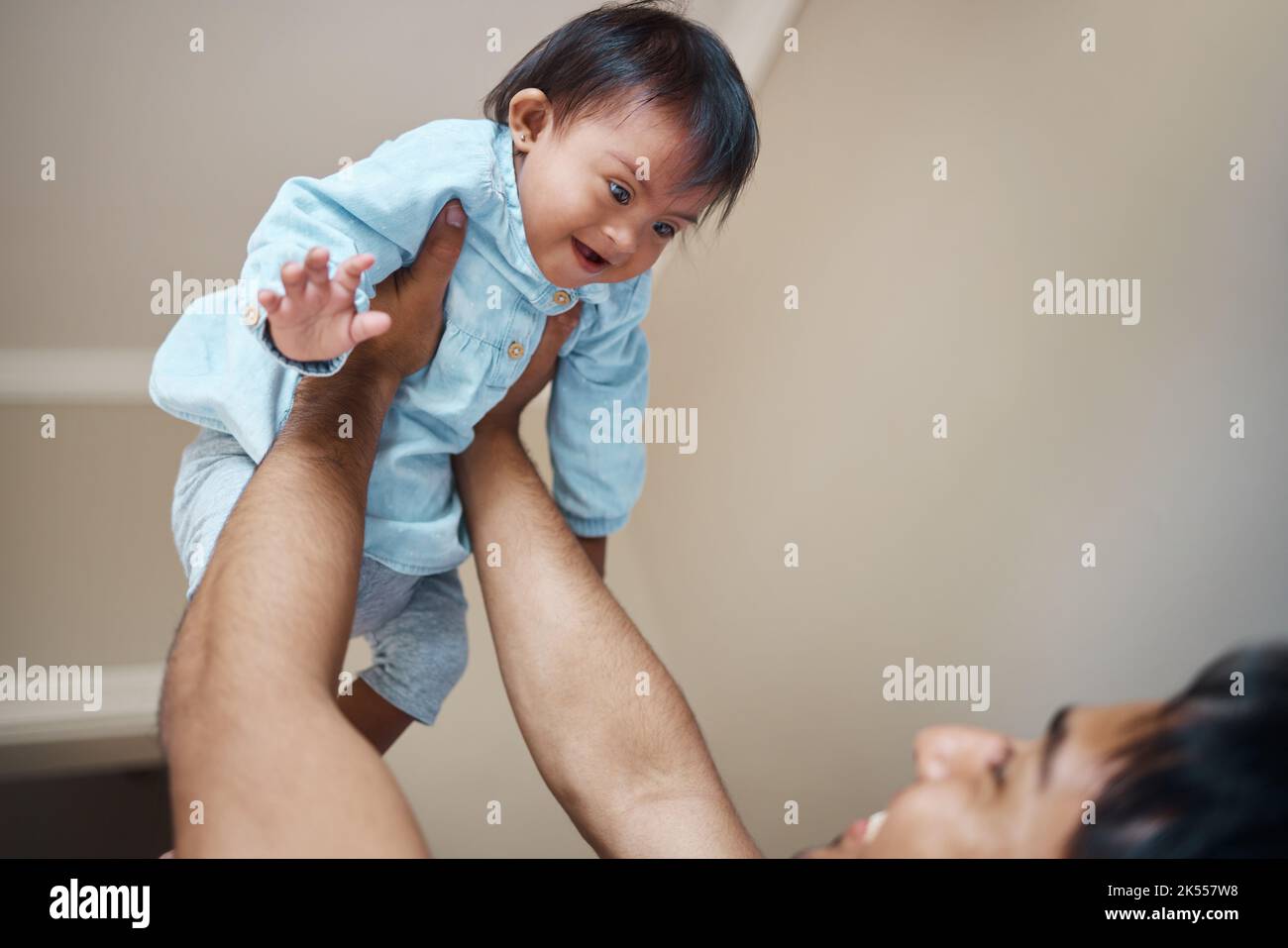 Down syndrome, baby and father with love for child, smile for care and happiness in their house. Newborn kid with disorder or condition happy, playing Stock Photo