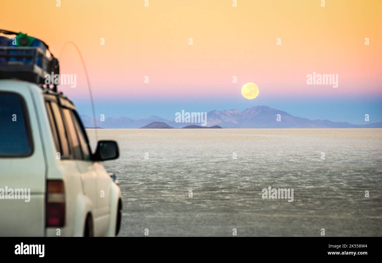 Full moon sunset with off road jeep vehicle on Salar De Uyuni World