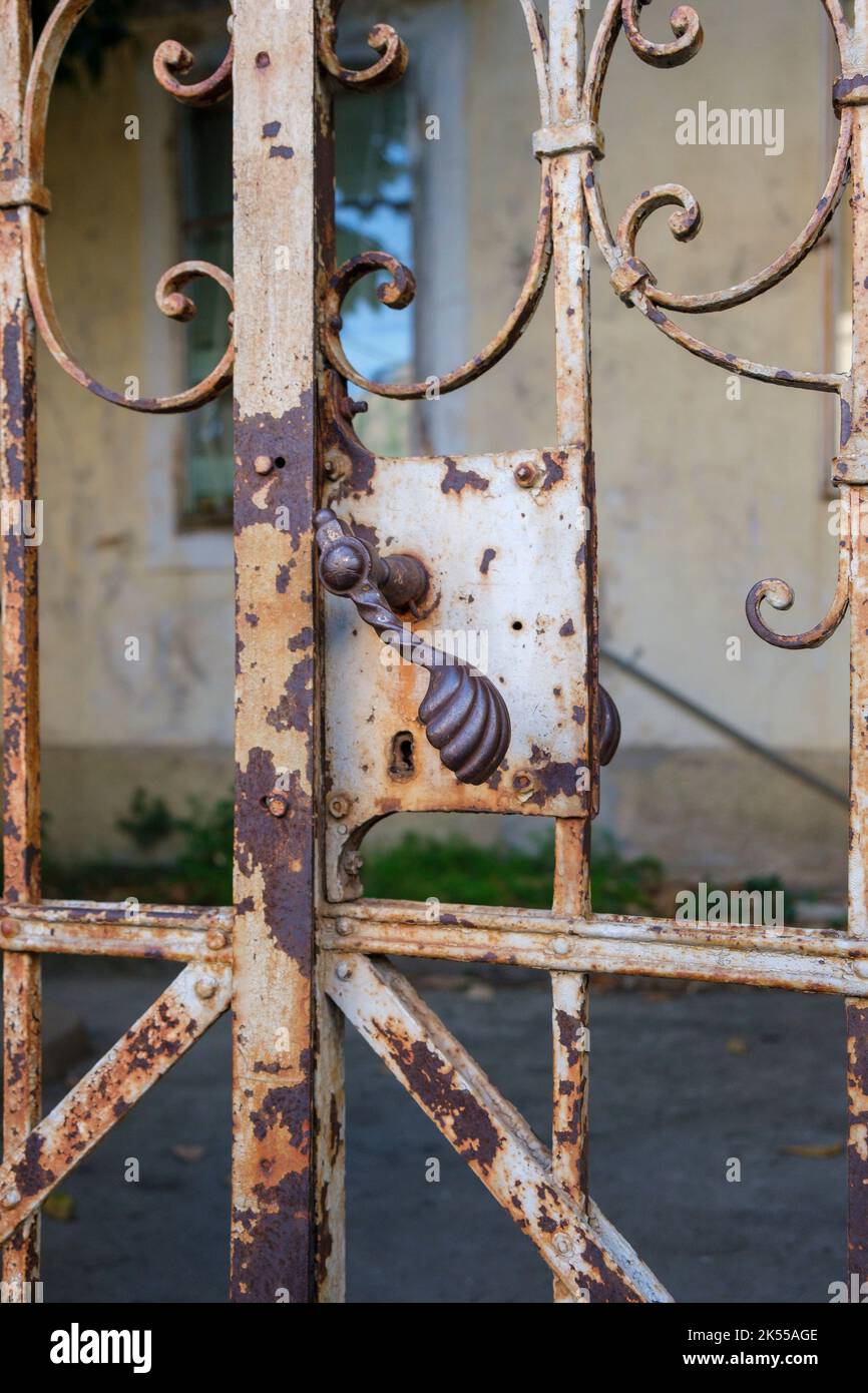 Old gate, rusty and weathered leading to properties that look alittle run down. Stock Photo