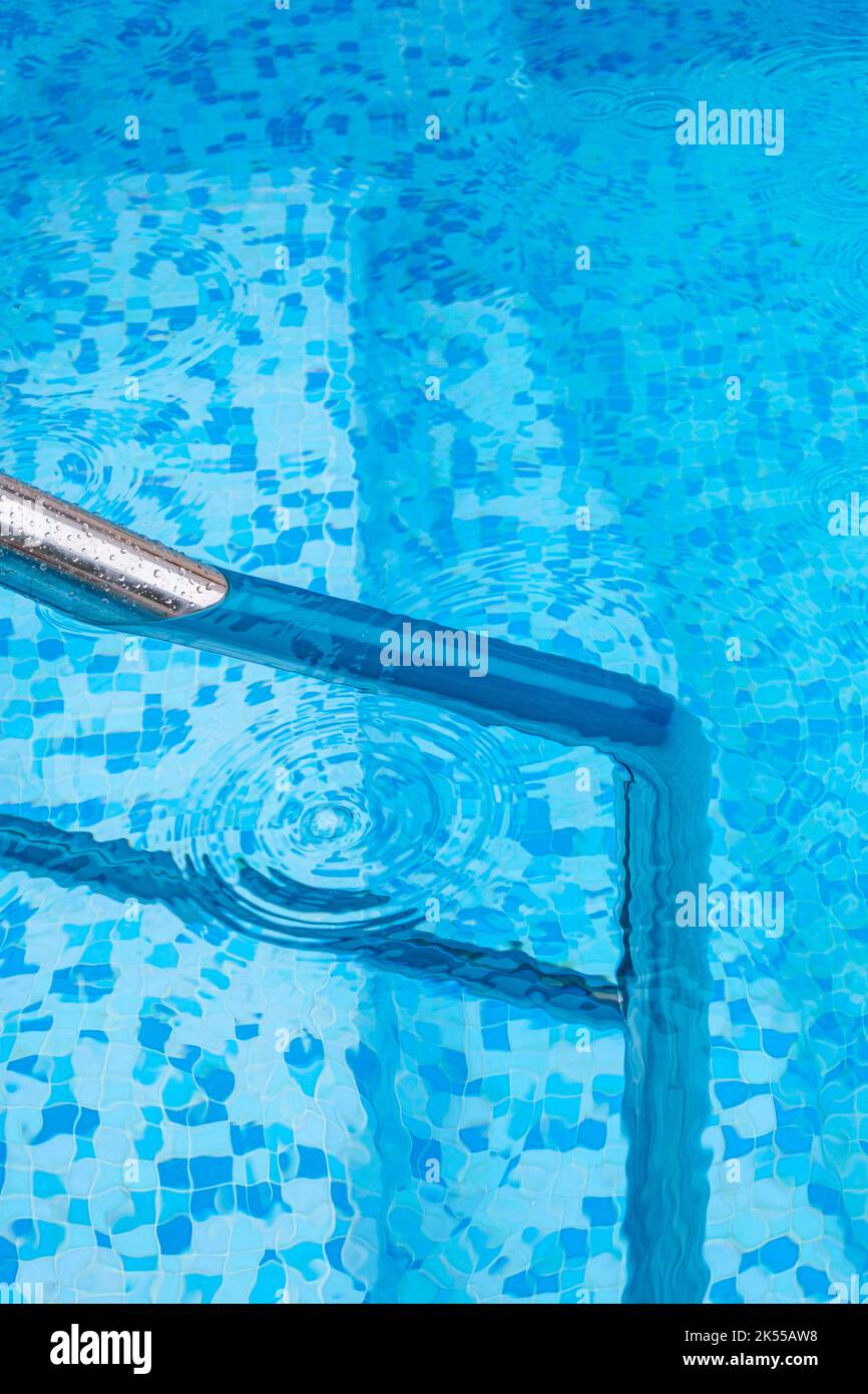 A deep blue swimming pool with steel rail to help entry and exit Stock ...