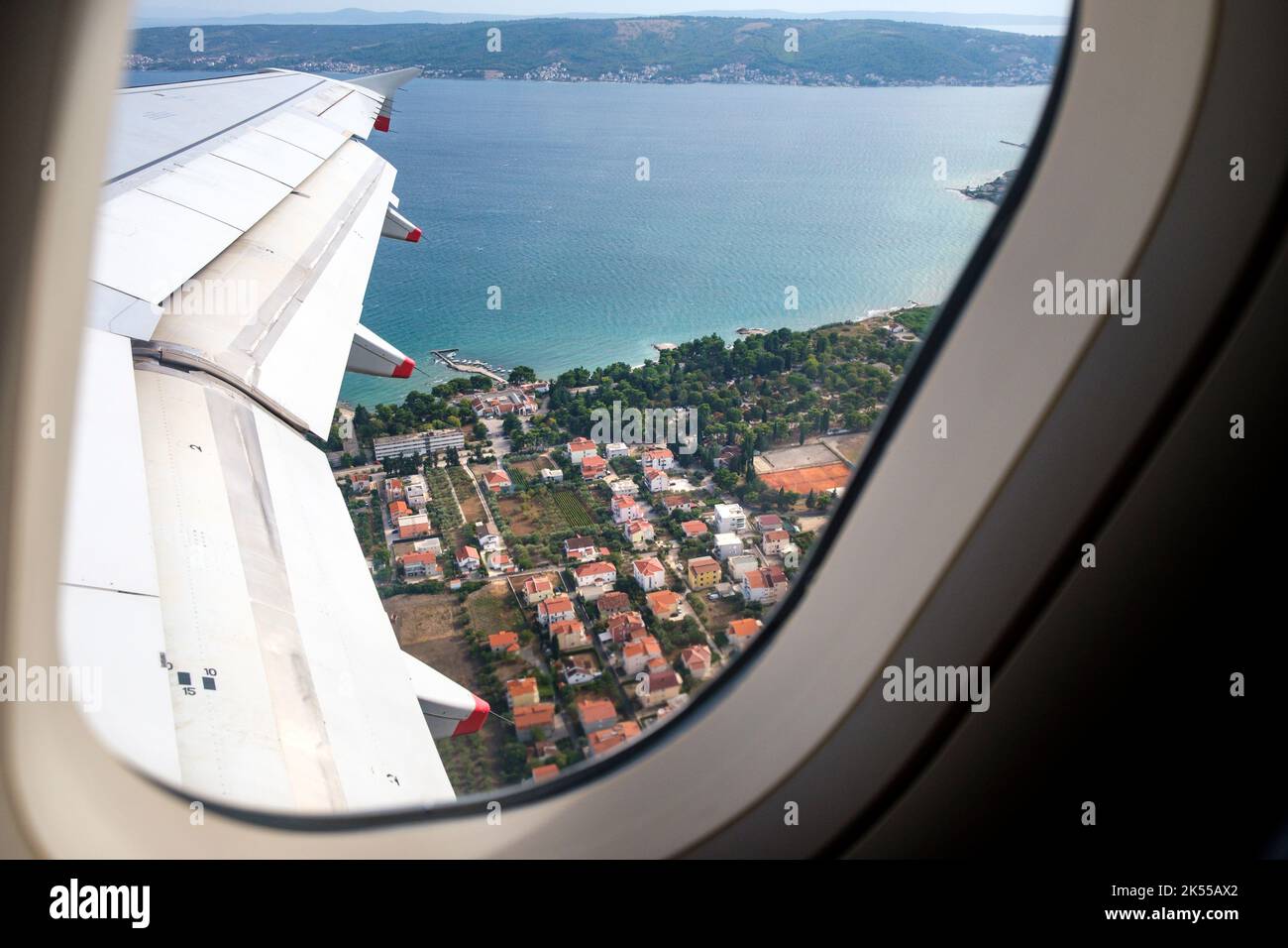 Looking out of the window of an aeroplane at the wing during take off from Split airport in Croatia. Stock Photo