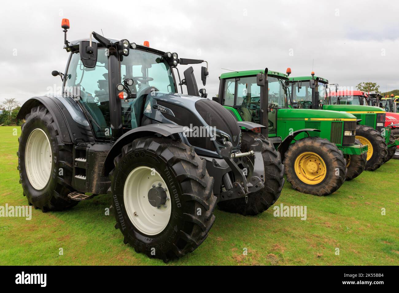 Brydkirk, Scotland - September 04, 2022: Side view of a Valtra N154 with two John Deere tractors in the background Stock Photo