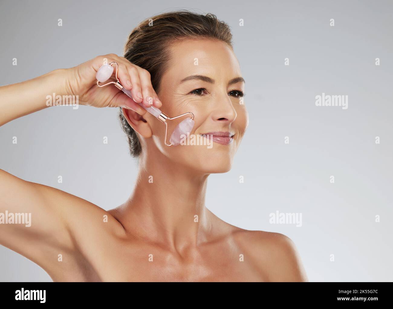 Skincare, rose quartz and beauty of a senior woman busy with a cosmetic