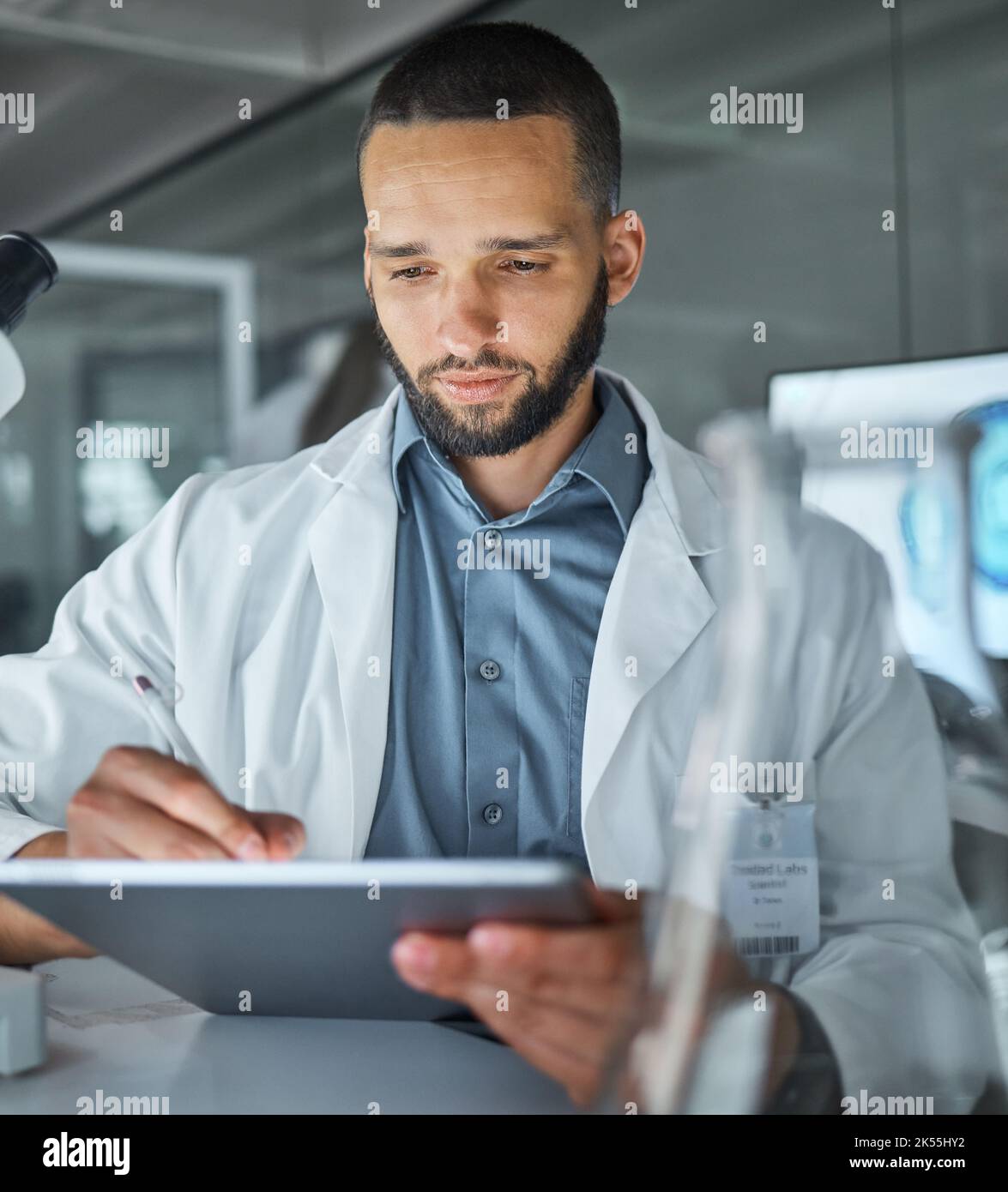 Scientist, lab and man writing on tablet for medical dna research, data analysis or recording results for medicine innovation. Science, tech and Stock Photo