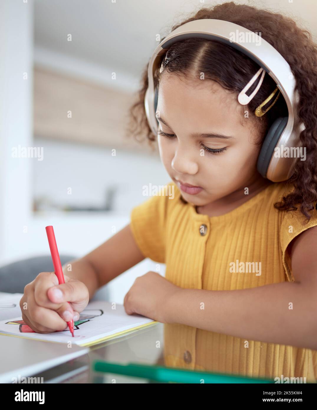 Girl, home and music while drawing in book for homework, assignment or fun in home. Child, writing and notebook while creative with headphones for Stock Photo