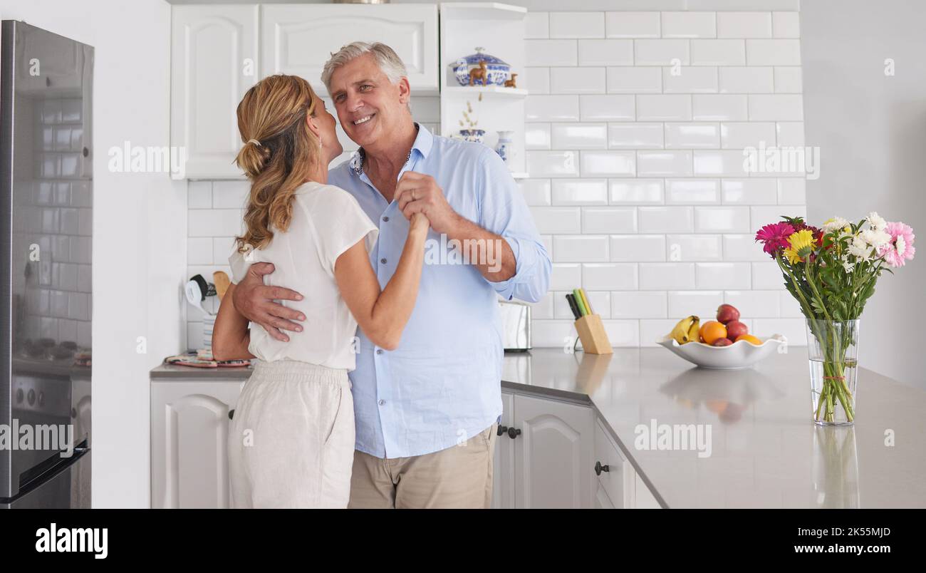 Elderly, couple and dance in home kitchen together for fun, bonding and romance. Senior man, woman and retirement dancing in house to show love Stock Photo