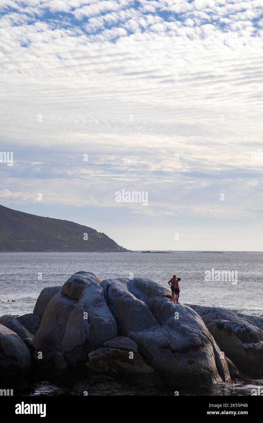 Two men on Rocks at Bakoven Beach in Cape Town, South Africa Stock Photo