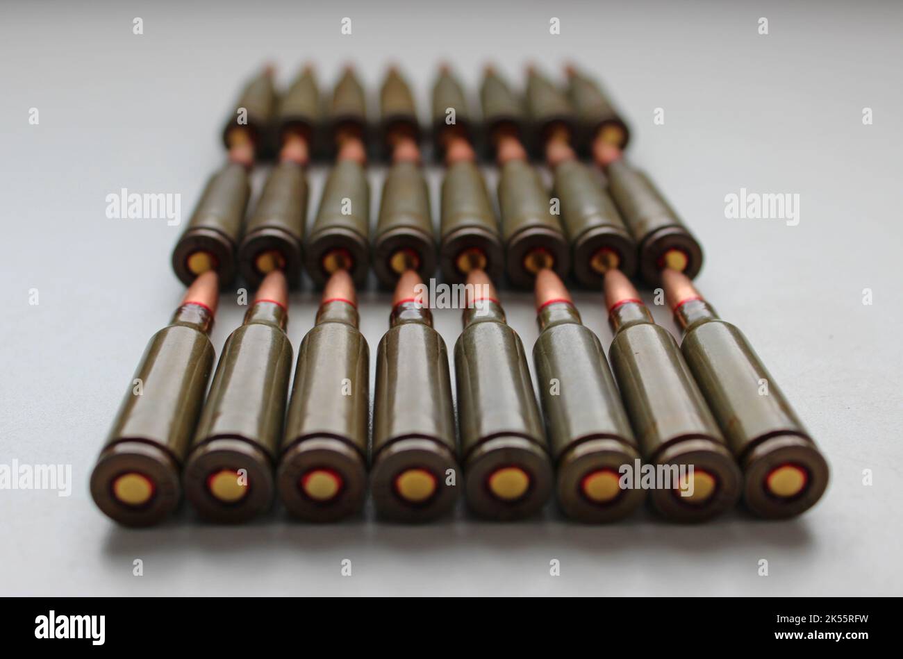 Closeup View Of live ammunition capsules for assault rifle laid out in rows on white background Stock Photo