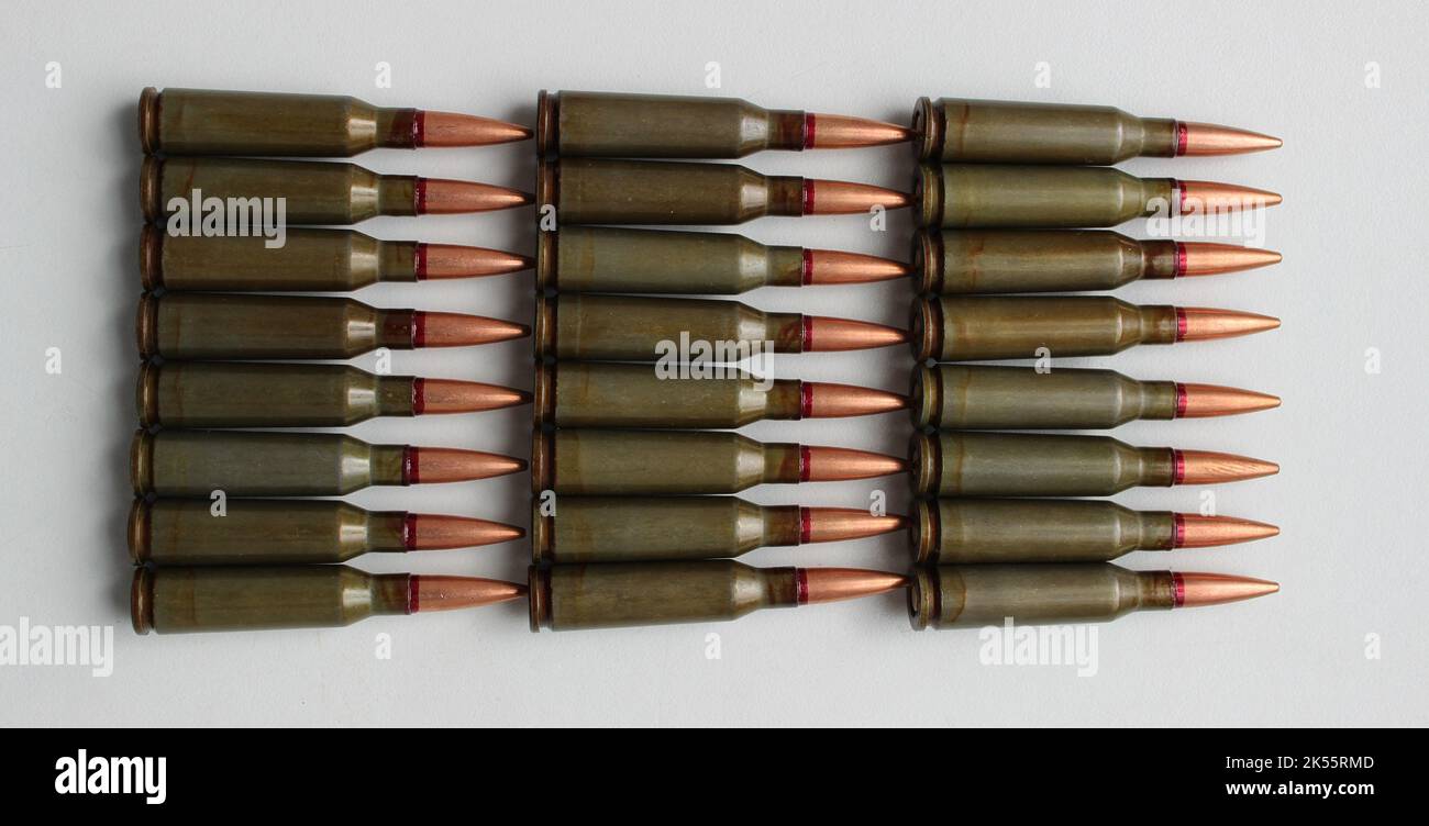 Live ammunition caliber 5.45 laid out eight in a rows on a white surface top view Stock Photo